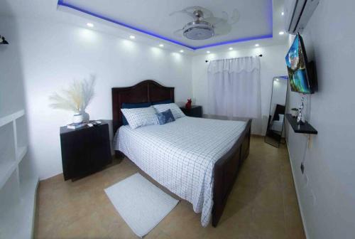 a bedroom with a bed and a tv in it at MODERN 3 BDRM KING BED 2BATHRM HOT WATER WIFI in Santo Domingo