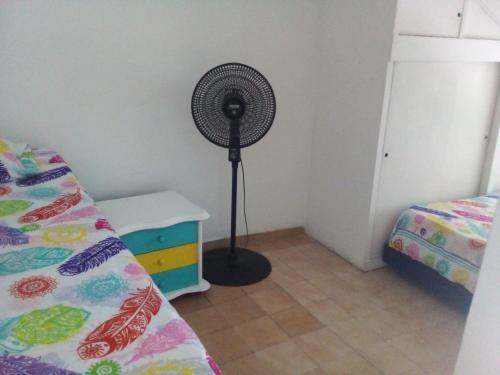 a room with a fan next to a bed at Casa Grace Apto con vista al mar in Cartagena de Indias
