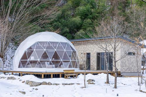 a building with a dome in the snow at mokki STARDUST GLAMPING in Achi
