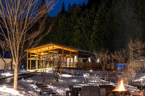 a large glass building in the snow at night at mokki STARDUST GLAMPING in Achi