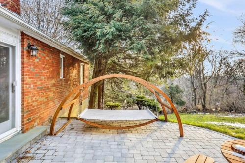 a bench sitting on a patio next to a house at 3 Bedroom Hilltop Escape with 5 Private Acres and Hot Tub in Marlboro