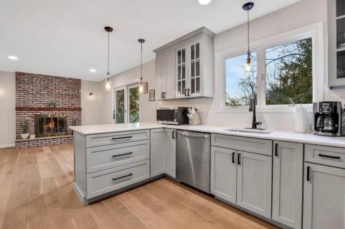 a kitchen with white cabinets and a fireplace at 3 Bedroom Hilltop Escape with 5 Private Acres and Hot Tub in Marlboro