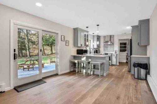 a large kitchen with wooden floors and stainless steel appliances at 3 Bedroom Hilltop Escape with 5 Private Acres and Hot Tub in Marlboro