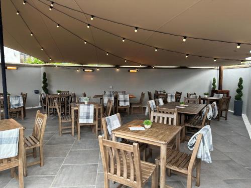 a dining room with wooden tables and chairs at Holiday Inn Aberdeen West by IHG in Westhill 