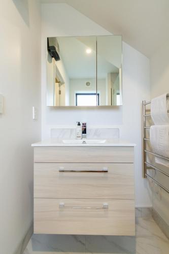 a bathroom with a sink and a mirror at Tuam Street Treasure- 2 Bed 2 Bath in Christchurch