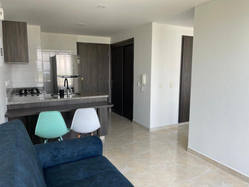 a living room with a blue couch and a kitchen at Santorini Elite in Pereira