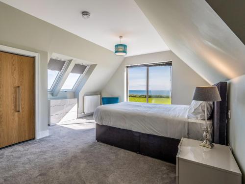 a bedroom with a bed and a large window at Murlin in Collieston