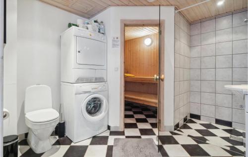 a bathroom with a washing machine and a toilet at Amazing Home In Hasle With Wifi in Hasle