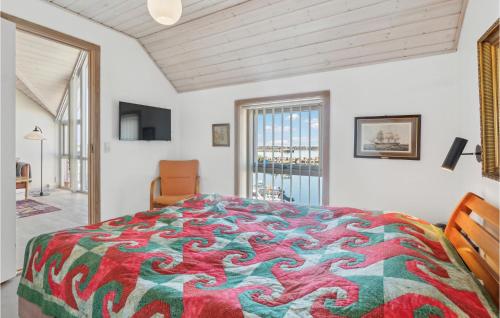 a bedroom with a large bed with a colorful blanket at Amazing Home In Hasle With Wifi in Hasle