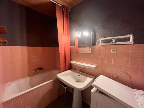 ein rosafarbenes Badezimmer mit einem Waschbecken und einer Badewanne in der Unterkunft Studio Les Sables-d'Olonne, 1 pièce, 4 personnes - FR-1-197-431 in Les Sables-dʼOlonne