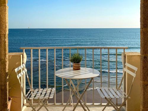 a table and chairs on a balcony overlooking the ocean at Appartement en front de mer avec vue imprenable sur la grande plage des Sables d'Olonne in Les Sables-dʼOlonne