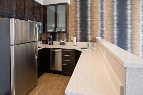 a kitchen with a stainless steel refrigerator and wooden cabinets at Residence Inn by Marriott Louisville East/Oxmoor in Louisville