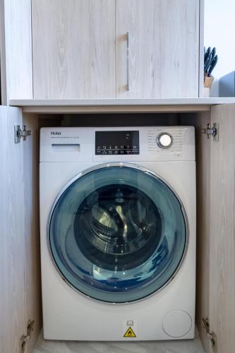 a washing machine in a cabinet with a blue at Tuam Street Treasure- 2 Bed 2 Bath in Christchurch