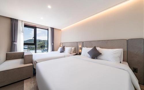 Postel nebo postele na pokoji v ubytování Hound Hotel Gijang Osiria