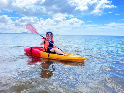 a woman sitting on a kayak in the water at Full Moon Village Resort in Mui Ne