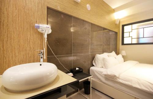 a bathroom with a sink and a bed at Bandal Hotel in Busan