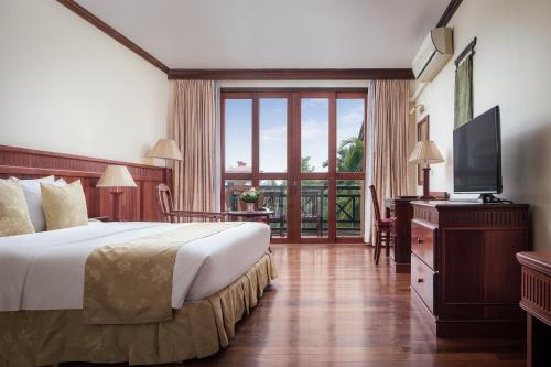 a hotel room with a bed and a television at Angkor Paradise Hotel in Siem Reap