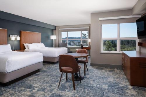 um quarto de hotel com duas camas, uma secretária e uma mesa em Four Points by Sheraton Victoria Gateway em Victoria