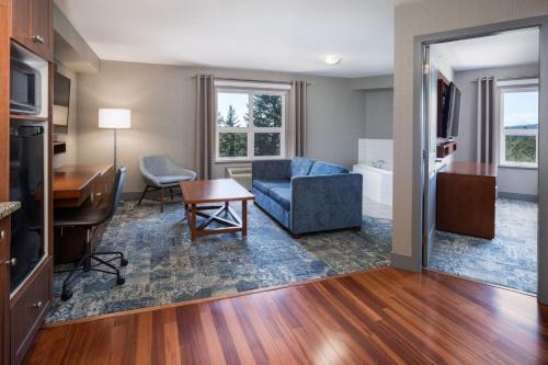 a living room with a blue couch and a table at Four Points by Sheraton Victoria Gateway in Victoria