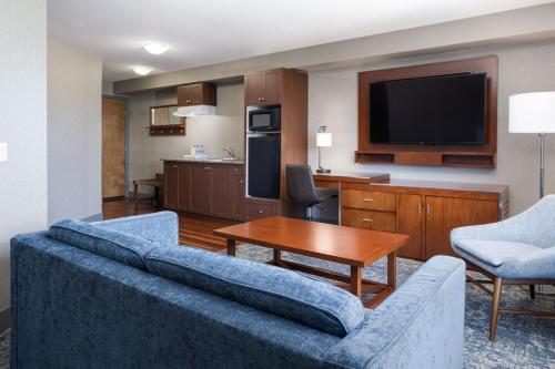 a living room with a couch and a tv at Four Points by Sheraton Victoria Gateway in Victoria