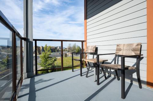 two chairs and a table on the balcony of a house at Four Points by Sheraton Victoria Gateway in Victoria