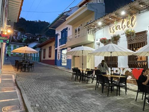 a group of tables and chairs with umbrellas on a street at JericóHouse apto 202 in Jericó