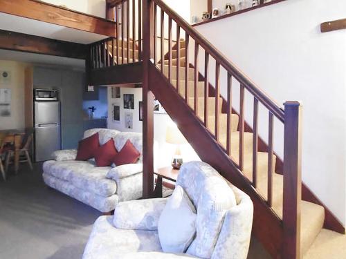 a living room with two couches and a staircase at The Granary in Burscough