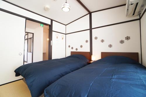 two beds in a room with blue sheets at ANGO KYOTO Ⅰ in Kyoto