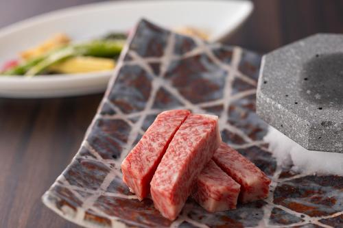 a plate of food with meat on a table at Biwafront Hikone in Hikone