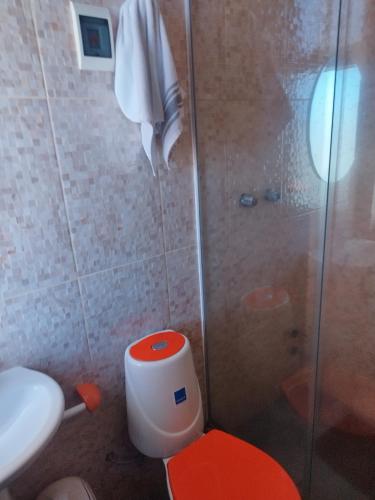 烏尤尼的住宿－HOSTAL YOKOSO，一间带红色卫生间和淋浴的浴室