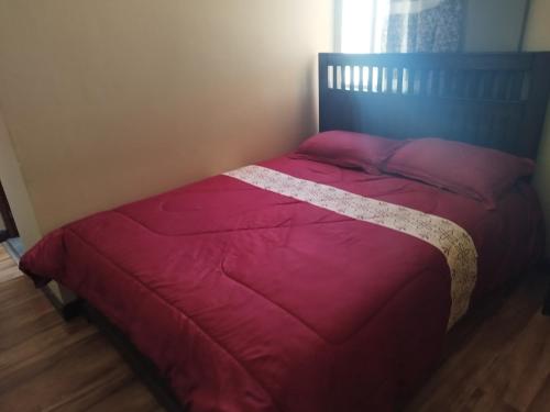 un letto in una camera da letto con piumone rosso di HOSTAL YOKOSO a Uyuni