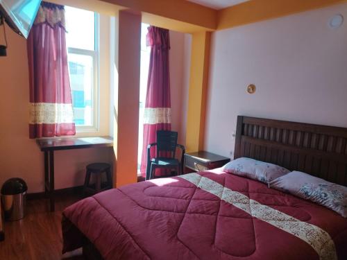 Schlafzimmer mit einem Bett, einem Schreibtisch und einem Fenster in der Unterkunft HOSTAL YOKOSO in Uyuni
