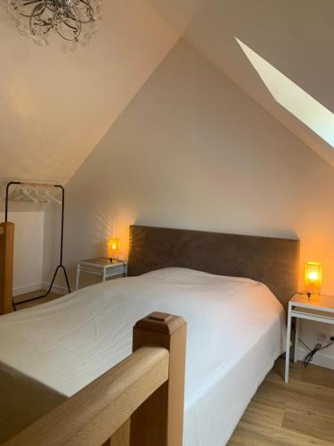 Un dormitorio con una cama blanca y dos lámparas. en Maison de charme ,Indépendante, en Montigny-sur-Loing