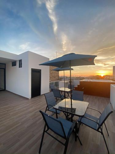a patio with a table and chairs and an umbrella at Depto nuevo “Tortuga”,Céntrico a 4 cuadras malecón in Mazatlán