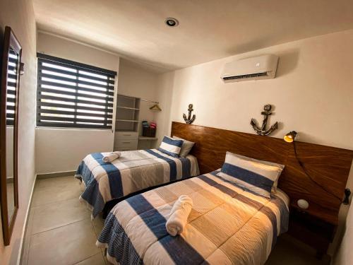 a bedroom with two beds and a window at Depto nuevo “Tortuga”,Céntrico a 4 cuadras malecón in Mazatlán