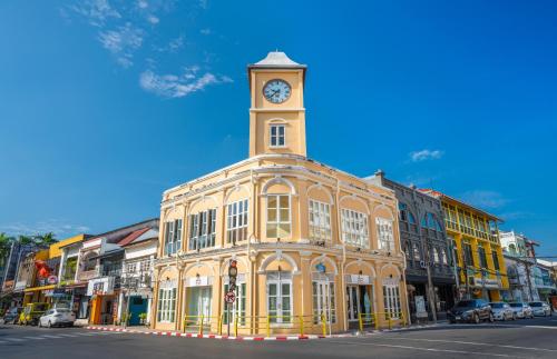um edifício com uma torre de relógio em cima em Book a Bed Poshtel - SHA Plus em Phuket