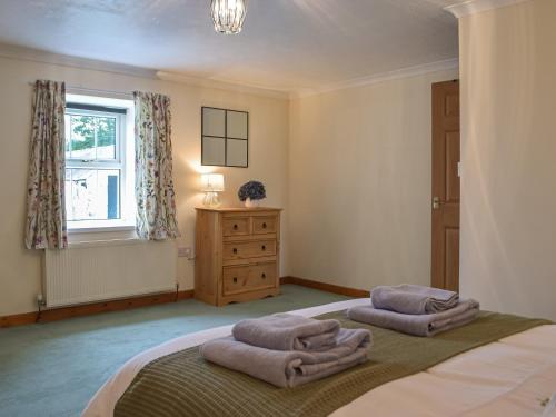 a bedroom with a bed with two pillows on it at Penrhiw Meredith in Llanfynydd
