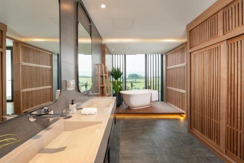 a bathroom with a tub and a sink and a bath tub at The Five Villas & Resort Ninh Binh in Tam Ðiệp