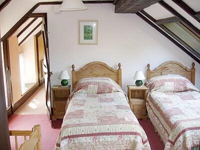 a bedroom with two beds and two lamps at The Stables Trap Farm in Wolves Newton