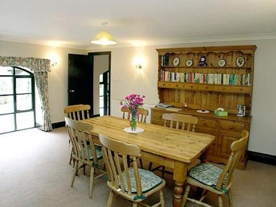 a dining room with a wooden table and chairs at The Stables Trap Farm in Wolves Newton