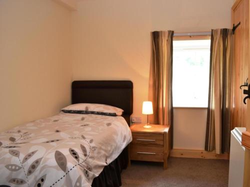 a bedroom with a bed and a window at Shepherds Cottage in Corney