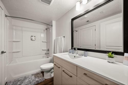 a bathroom with a sink and a toilet and a mirror at Sleek & Stylish Salt Lake City APT Prime Loc in Salt Lake City