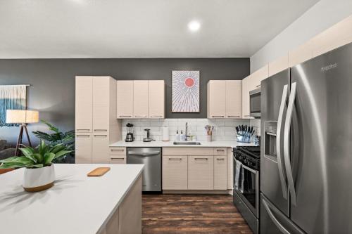 a kitchen with white cabinets and a stainless steel refrigerator at Affordable APT in Salt Lake City Ideal Location in Salt Lake City
