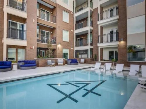a large swimming pool with chairs and a building at Affordable APT in Salt Lake City Ideal Location in Salt Lake City