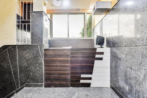 an office with a staircase and a desk with a monitor at SPOT ON Gayatri Comforts in Bangalore