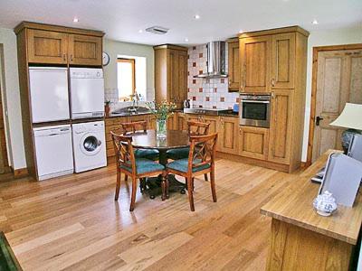 a kitchen with a table and chairs in a room at Milton Byre in Rothesay