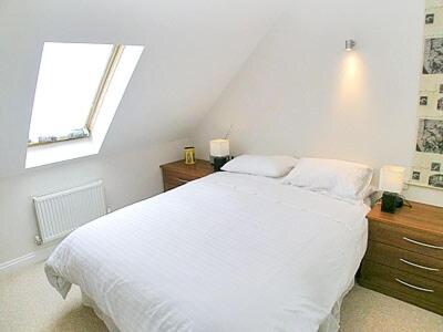 a bedroom with a white bed and a window at The Dairy in Cromer