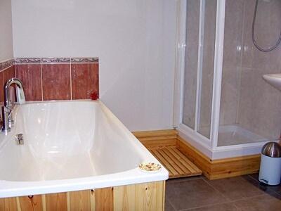 een badkamer met een groot bad en een douche bij The Old Stables in West Ashby