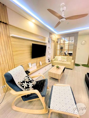- un salon avec deux chaises et une télévision dans l'établissement Homestay by ViJiTa 2bedroom condo, à Manille