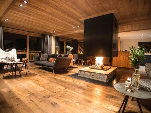 un salon avec une cheminée et une télévision dans l'établissement Chalet Luxueux 10 Pers. à Serre Chevalier - Terrasse, Local à Ski, Navette Gratuite - FR-1-762-18, à La Salle Les Alpes